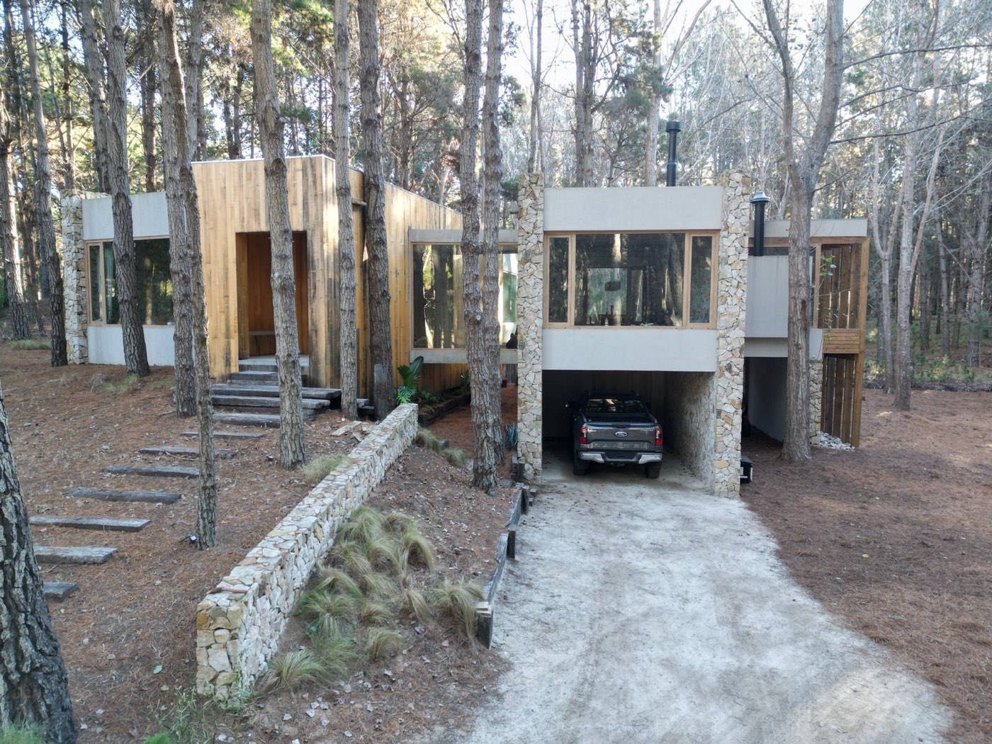 Casas de piedra y madera entre pinos, fotografía de arquitectura